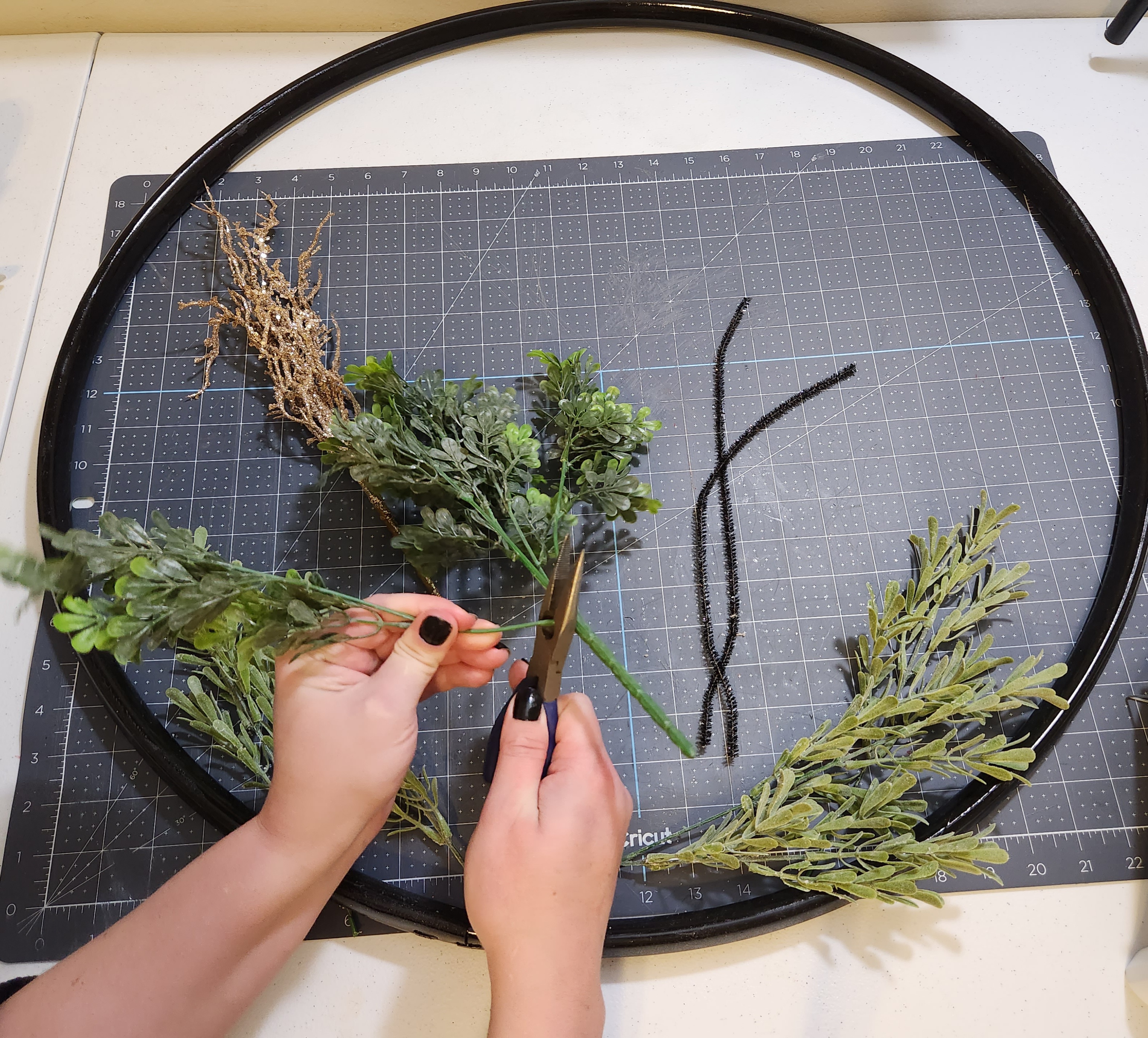 Cutting greenery stems from the bunch with wire cutters.