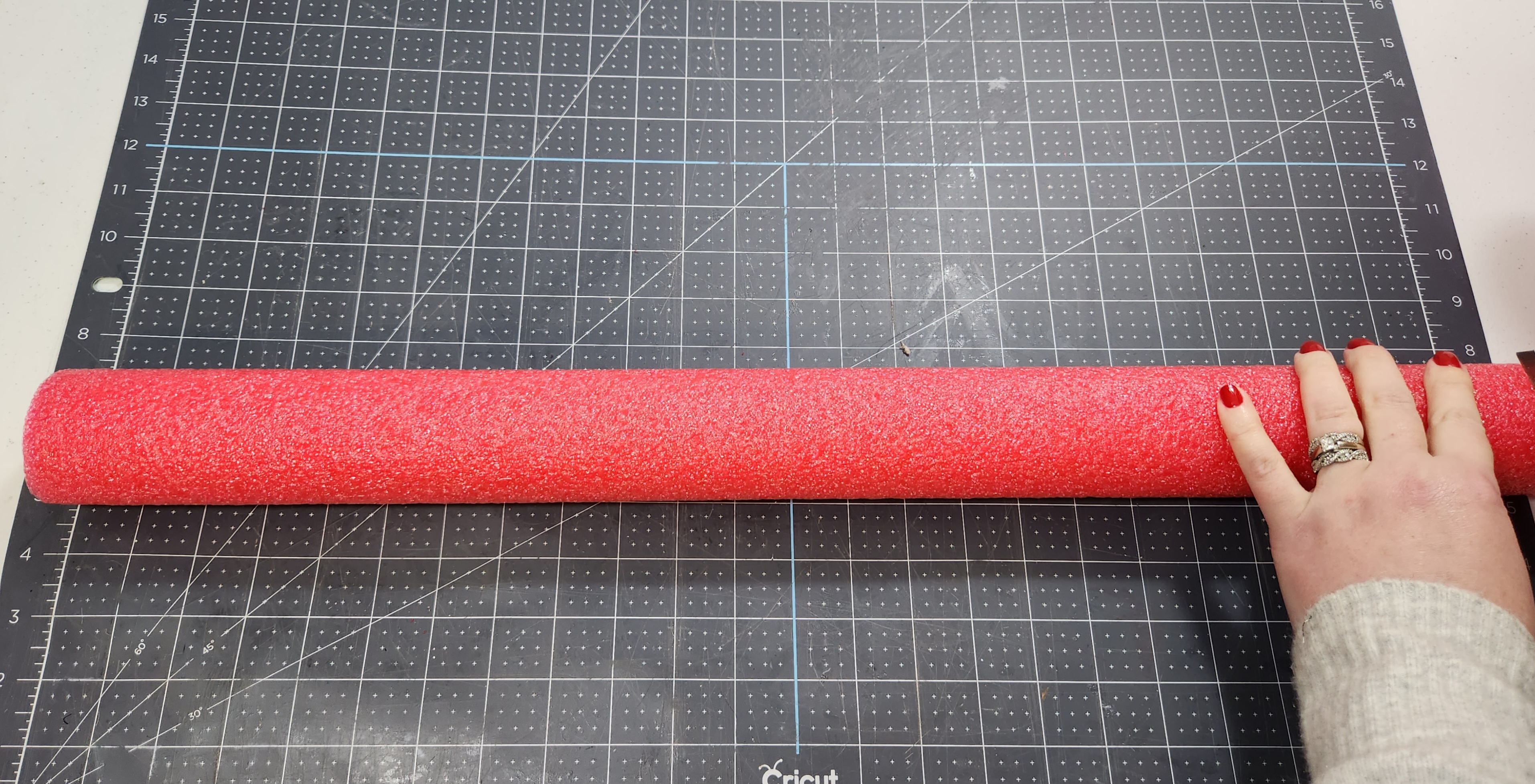 Cutting a pool noodle to 24" long.