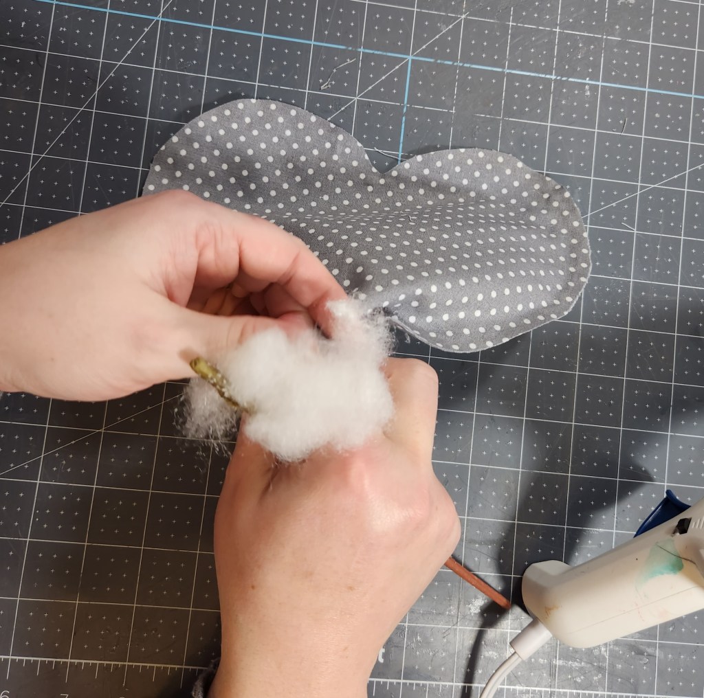 Stuffing a fabric heart with polyfill so that it will stand up in the centerpiece.
