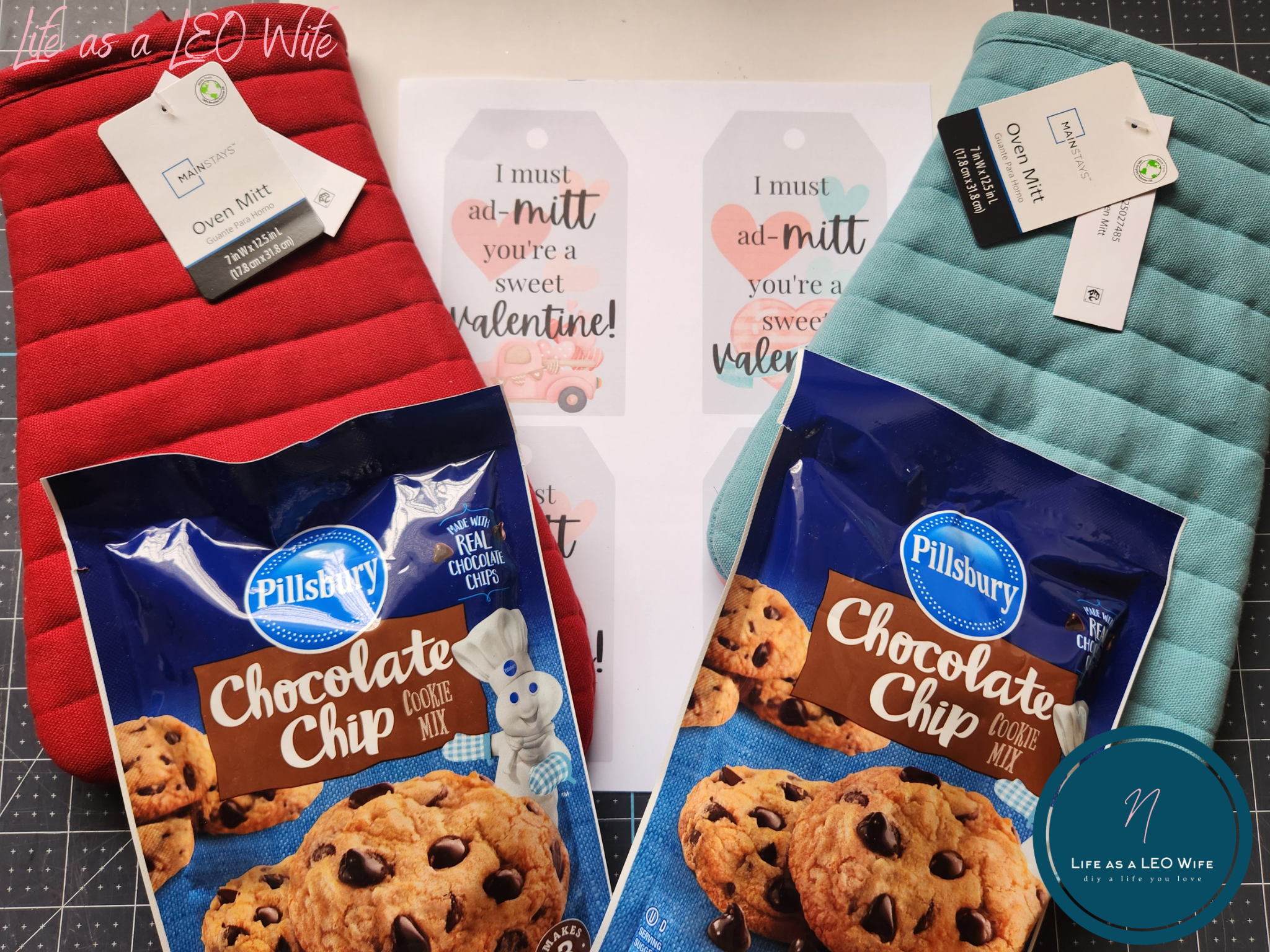 Supplies for a last minute Valentine's gift: 2 bags of chocolate chip cookie mix, a red oven mitt, a blue oven mitt, and my free printable Valentine's gift tag.
