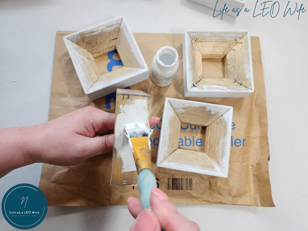 Painting 4x4 wood blocks with white chalk paint.