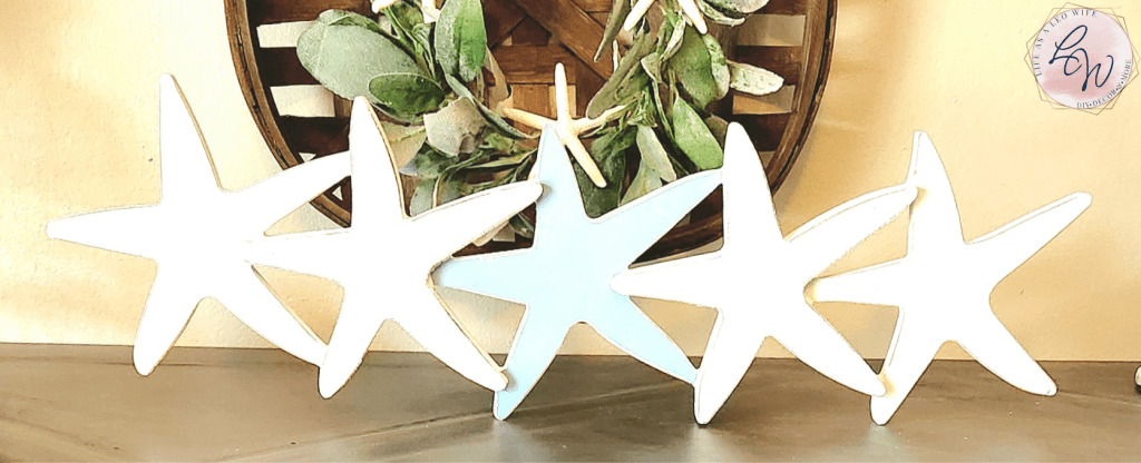 A wood coastal farmhouse tabletop decoration from Hobby Lobby that is 6 starfish in a line in blue, light blue, and white.