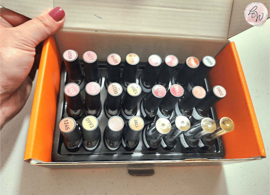 Orange box containing a Modelones gel manicure kit with 20 gel polish colors, a matte and regular top coat, a base coat, and a nail primer.