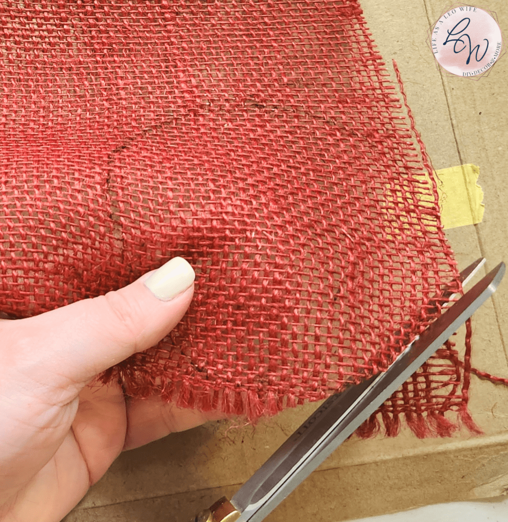 Cutting out the traced circle on the red burlap.