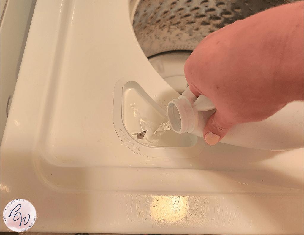 Pouring bleach into bleach dispenser to clean the washing machine.