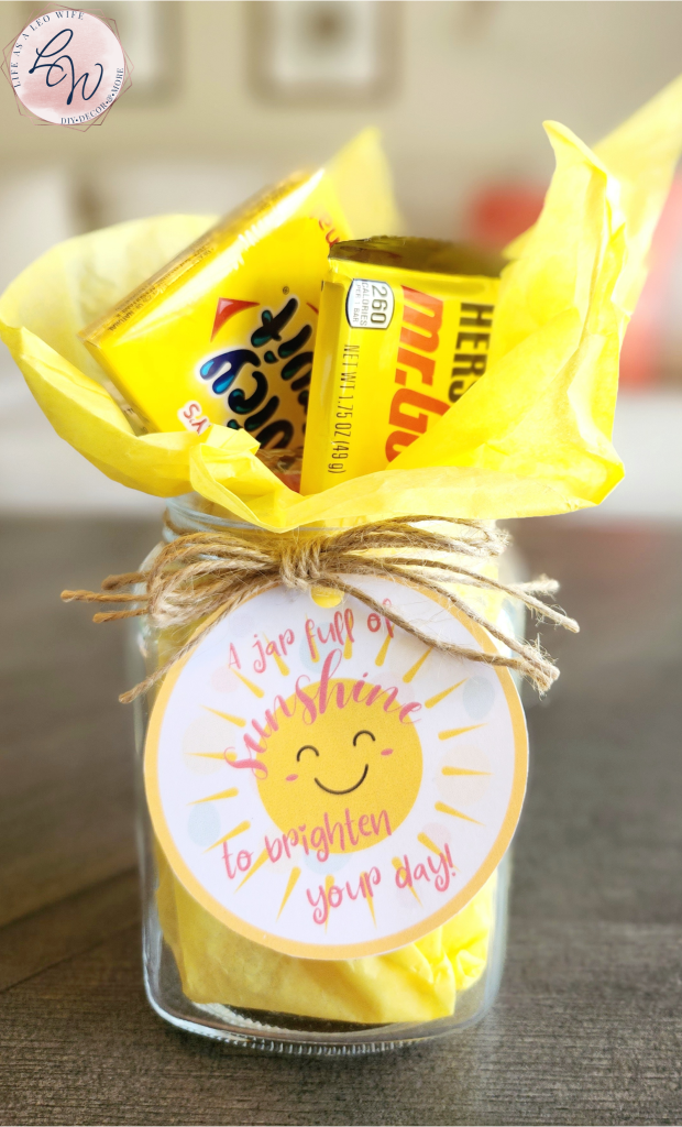 Complete sunshine jar filled with yellow tissue paper, Goldfish, Juicy Fruit gum, Mr. Goodbar, and peanut butter crackers.
