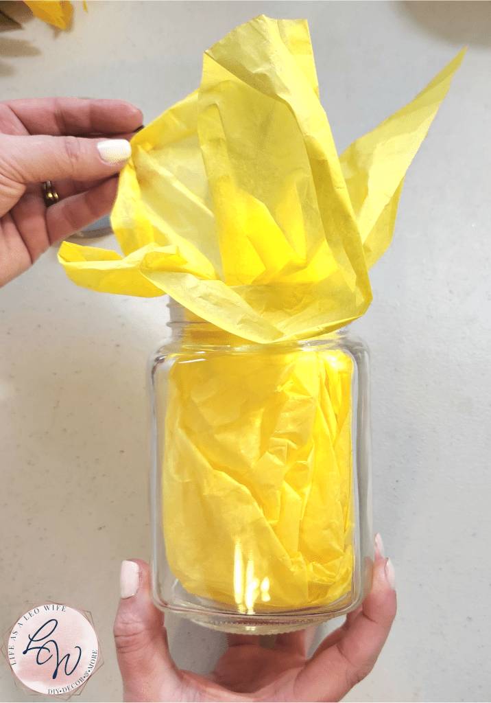 Yellow tissue paper placed in a glass jar as a base for the sunshine jar.