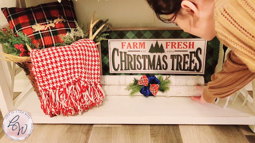 Placing a bundle of faux birch logs on the bottom of the mantle to finish off the Christmas decor.