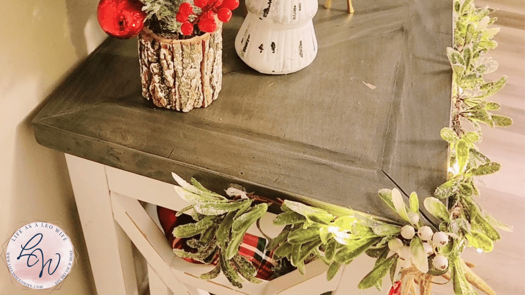 Olive leaf & white berry garland with warm white lights attached to the faux mantle on a Command hook.