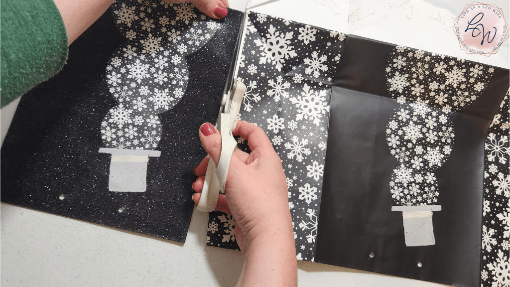 Cutting the front piece off of a Christmas gift bag.