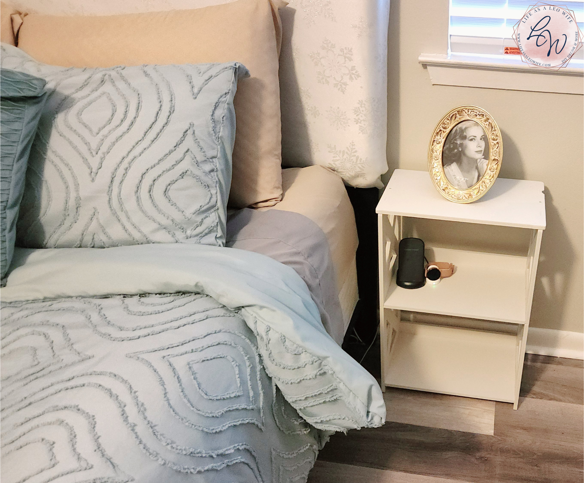 White nightstand replacing a larger black one with a gold picture on top.