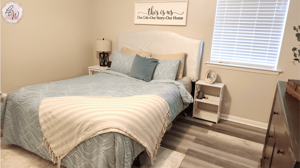 Picture of my master bedroom on week 3 of the bedroom refresh; new robin's egg blue bedding, tan throw, new white nightstands, new sign above the bed, and a beige & ivory farmhouse rug.