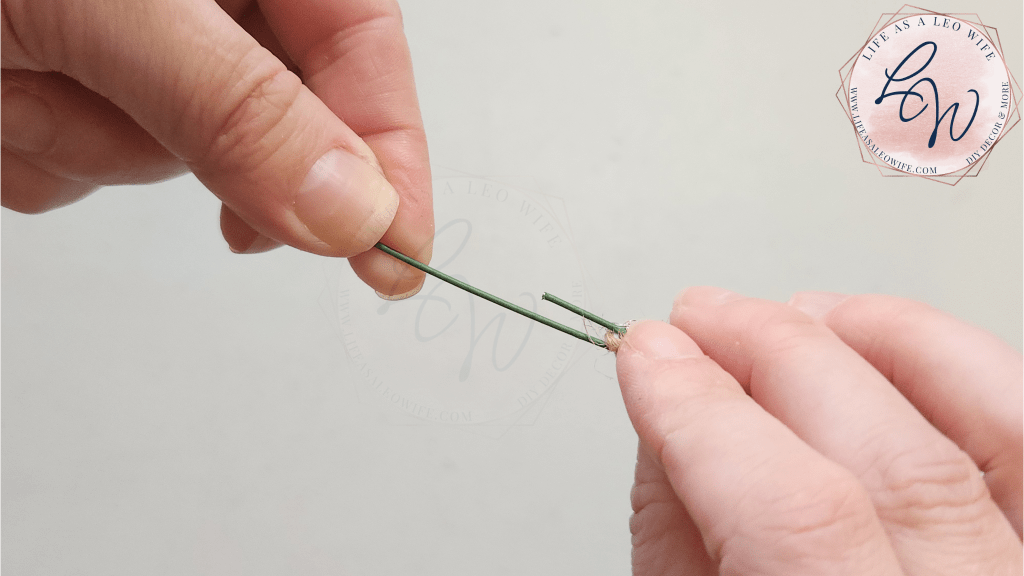 Pinching the twine on the end of the wire to form the bottom of the DIY Easter egg carrots.