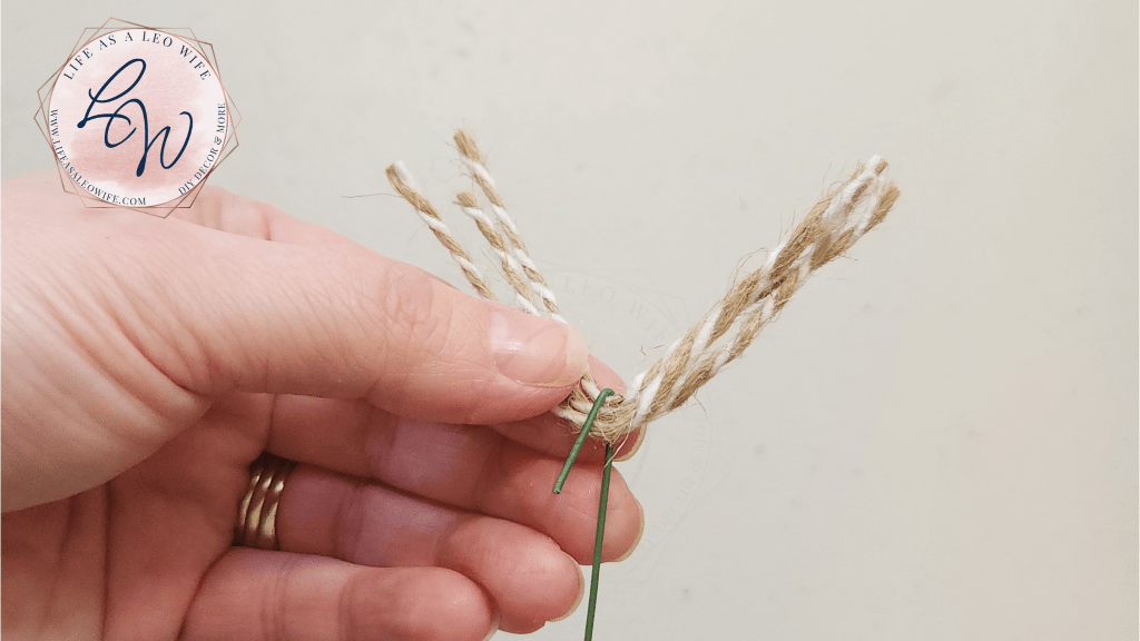Putting 3 pieces of twine in the bend of the floral wire to form the bottom of the DIY Easter egg carrot.