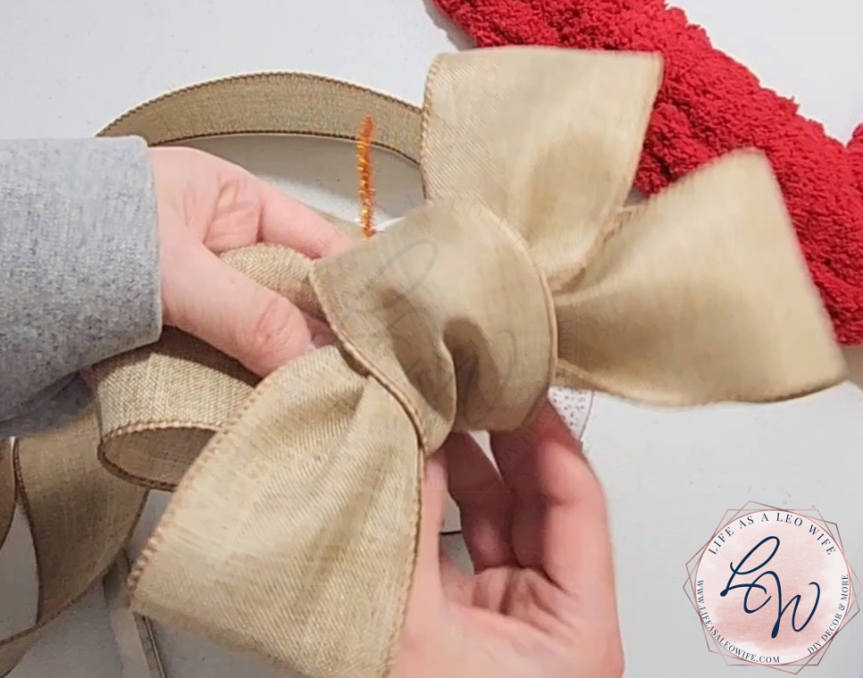Pulling the ribbon up & around the bow to cover the pipe cleaner & form the small center loop.