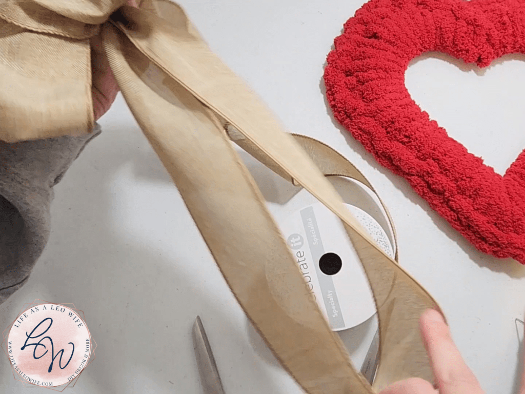 Bringing the ribbon down & back up to the easy bow to create tails.