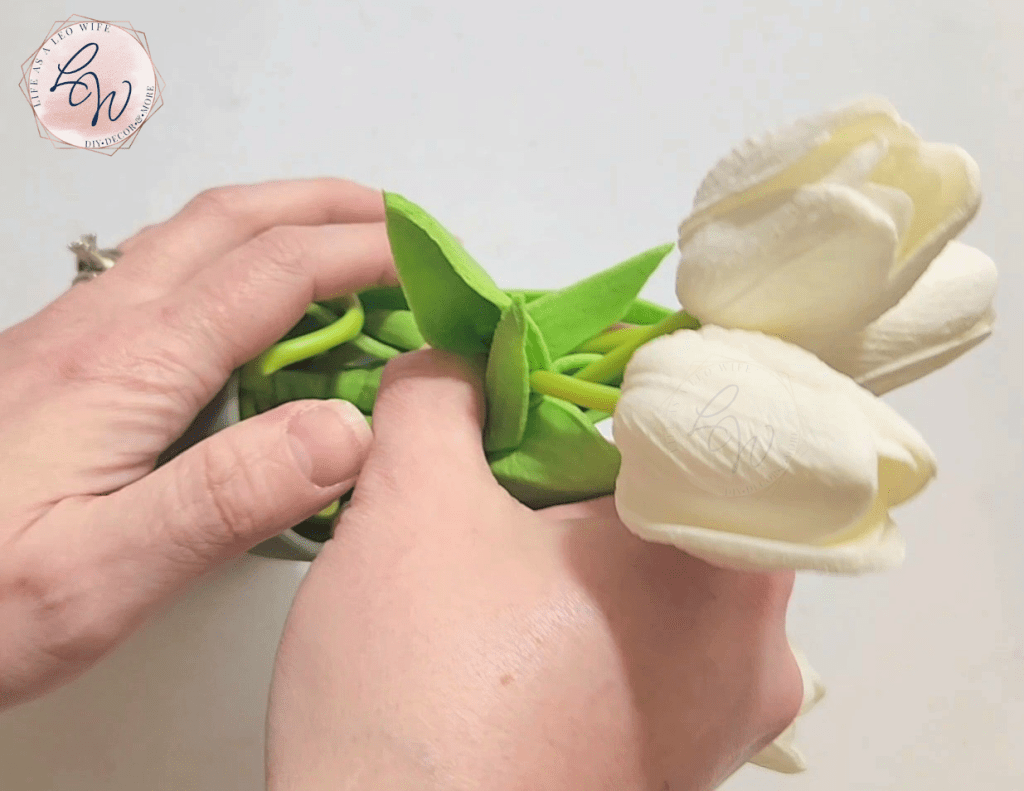 Placing real-touch tulips in a Dollar Tree terracotta pot glued to the top of a ceramic bunny as a DIY spring flowerpot.