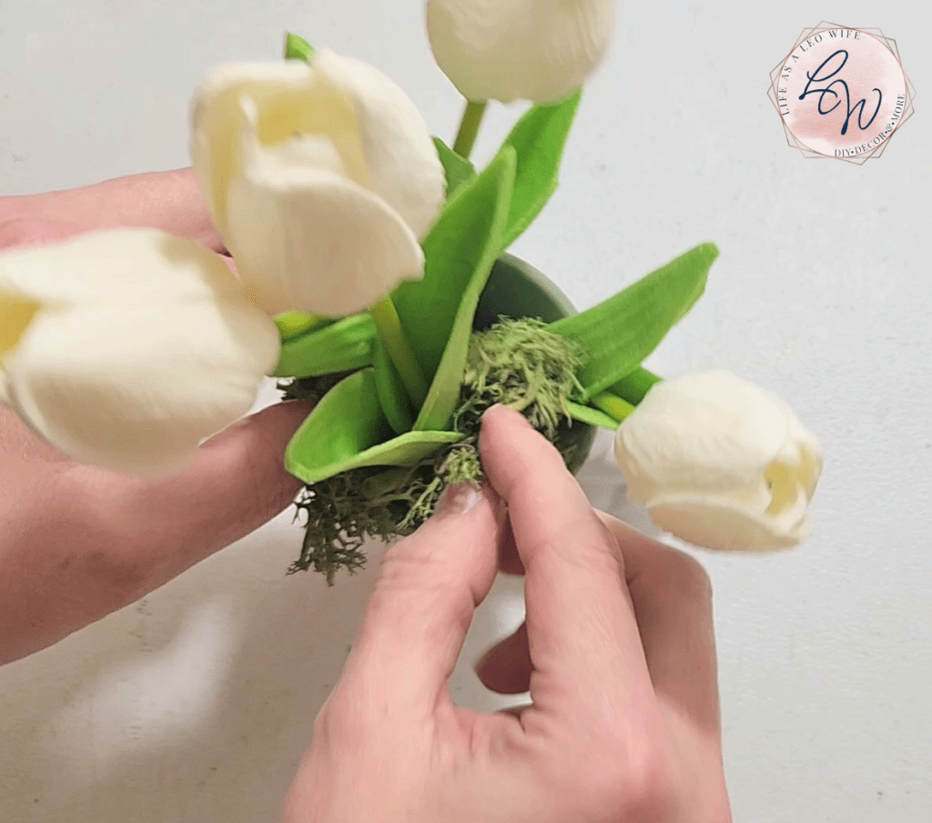 Placing moss inside a DIY spring bunny flowerpot.