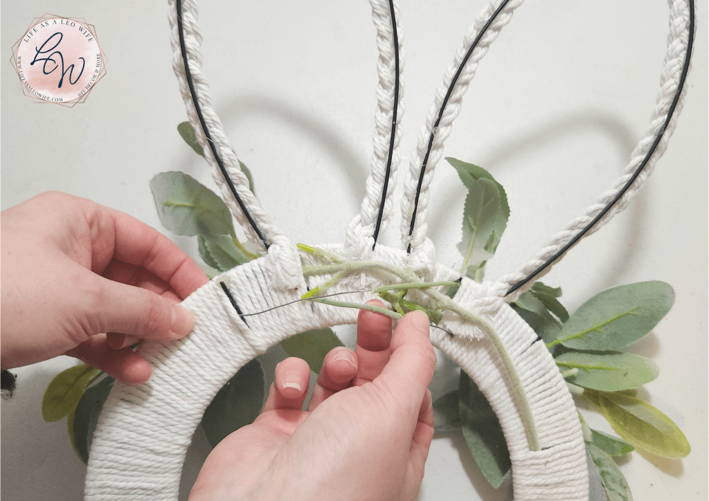 Back of the bunny wreath with the greenery & flower stems woven through the center of the macrame cord.