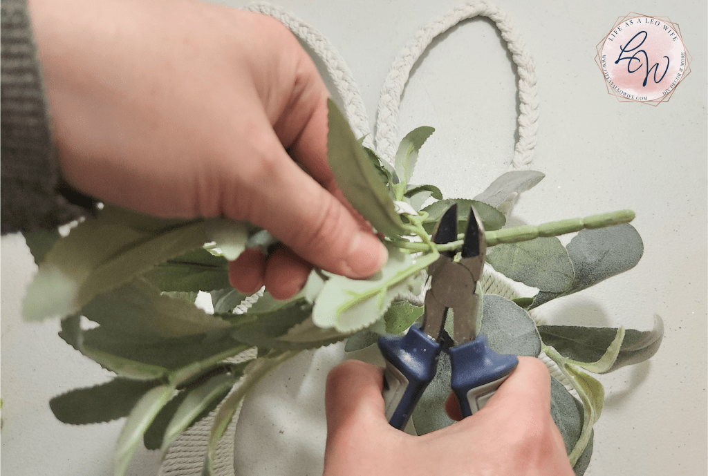Cutting a piece of greenery from the bunch with wire cutters.
