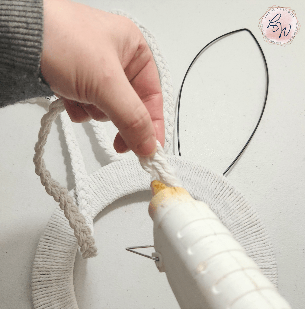 Putting hot glue on the end of the macrame cord braid to place on the bunny ear.