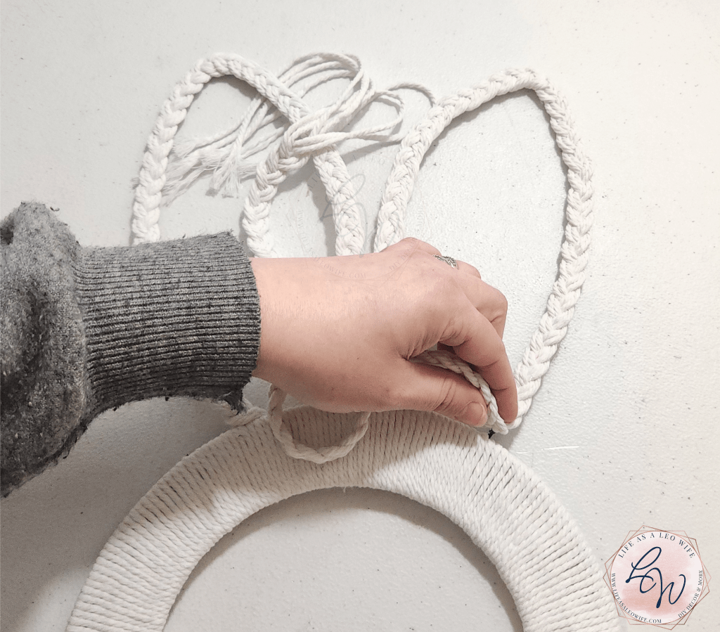 Pressing the last bit of the braid onto the bunny ear on the wreath form.