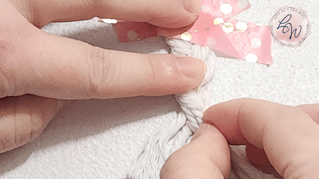 Pressing the macrame cord together at the end of the braid with the hot glue on it.