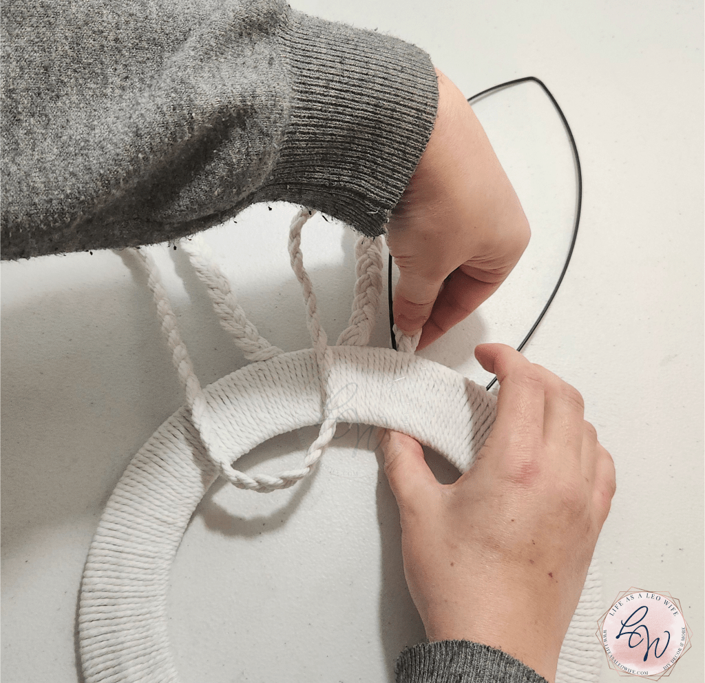 Taping the braided cord to the back of the ear on the bunny wreath.