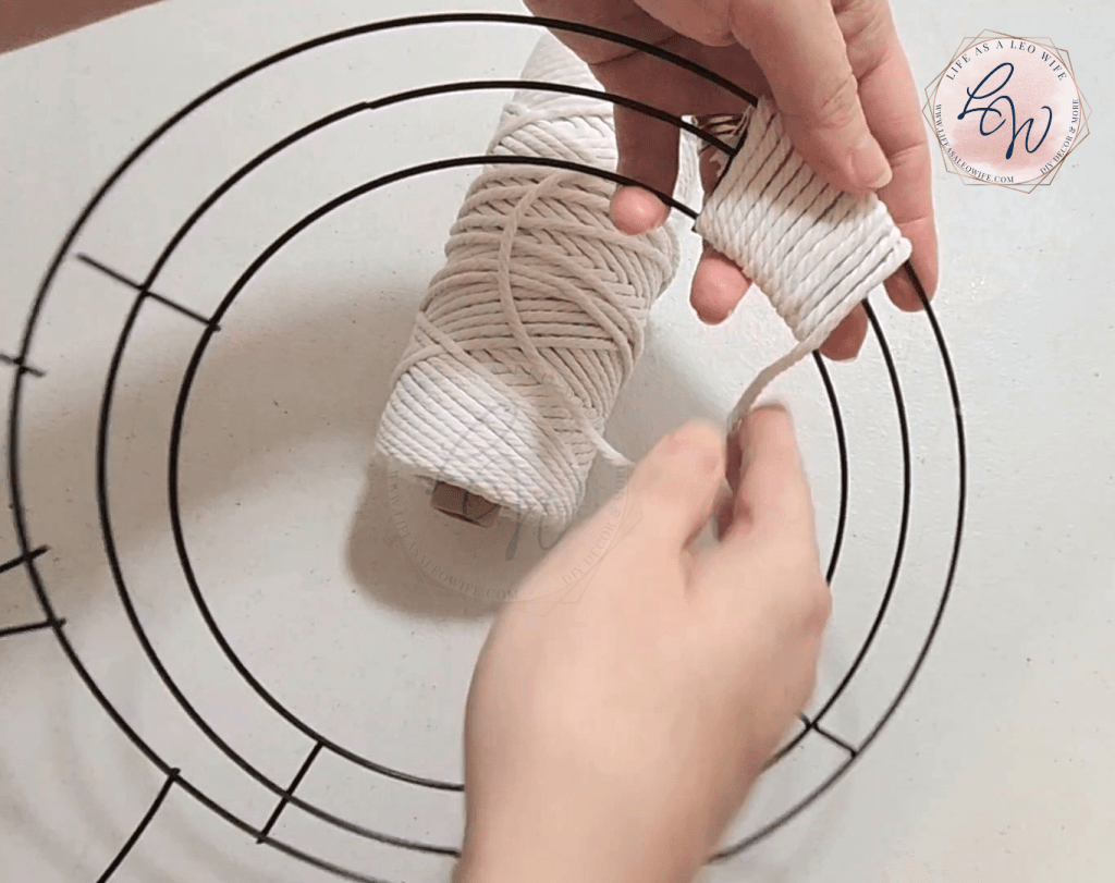 Wrapping white macrame cord around the bunny wreath frame with about 3" covered.