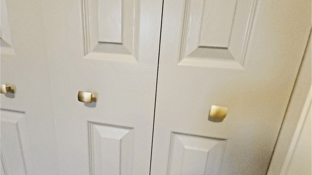 Closet doors with new gold, rectangle door knobs.