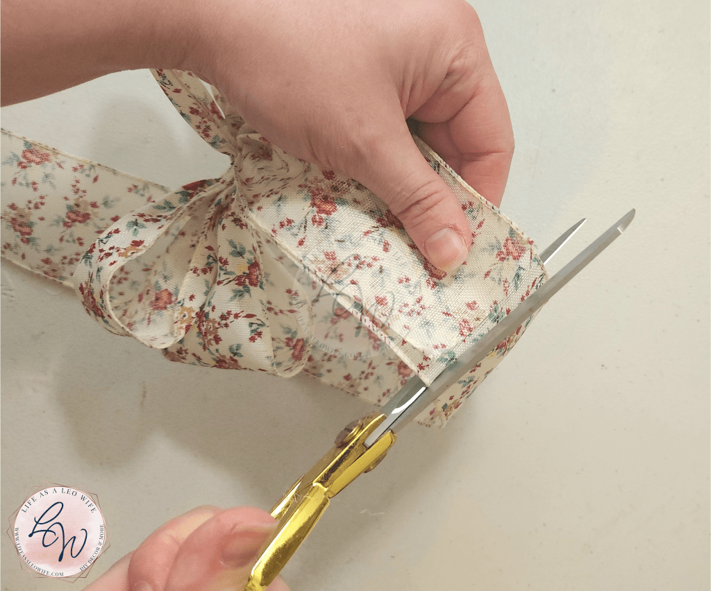 Cutting tails on the bow for the embroidery hoop pocket wreath.