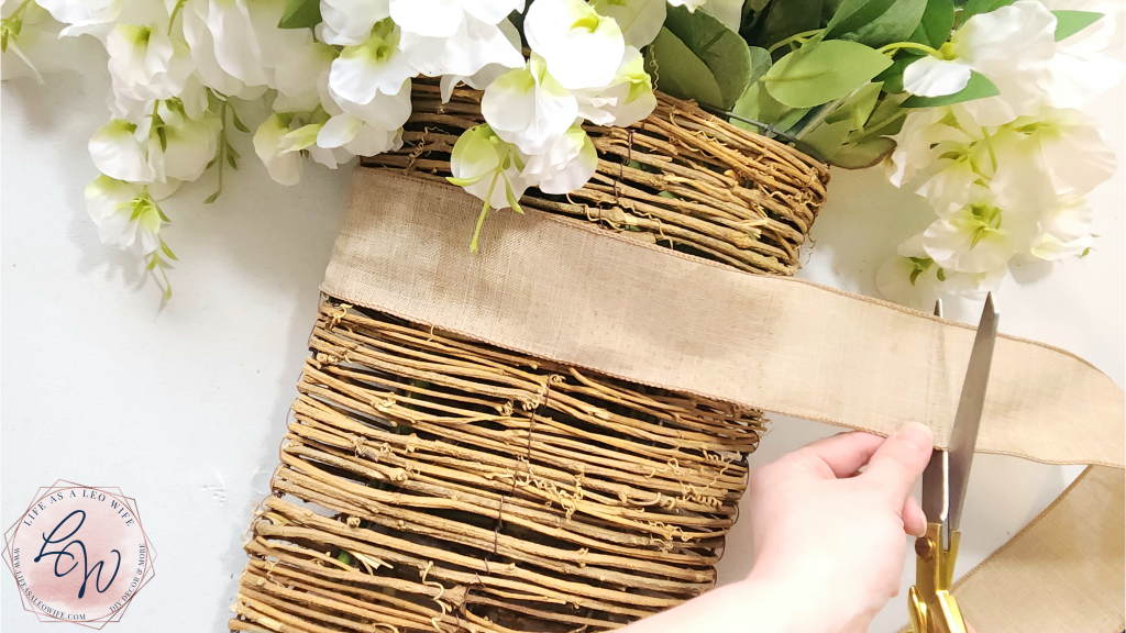 Cutting a strip of ribbon for the front of the floral door basket.